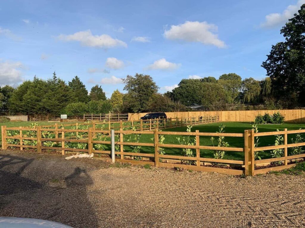 This is a photo of post and rail fencing and also feather edged fencing in the background